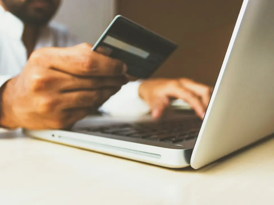 A person shopping online with a payment card